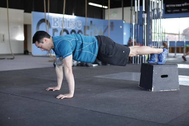 Flexão declinada (pés elevados): Início